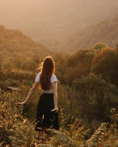 woman standing on grassy hill