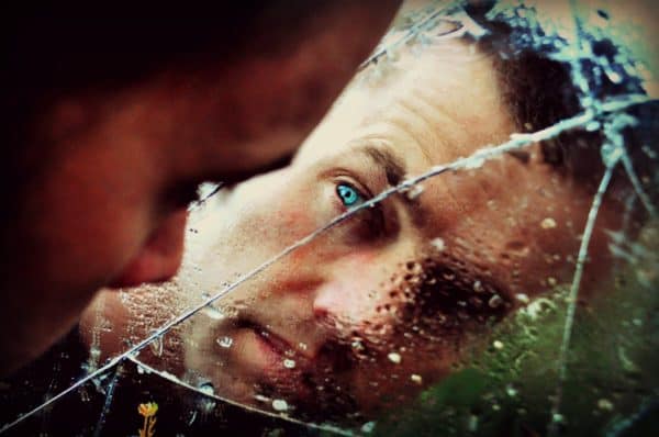 blue eyed man staring at the mirror