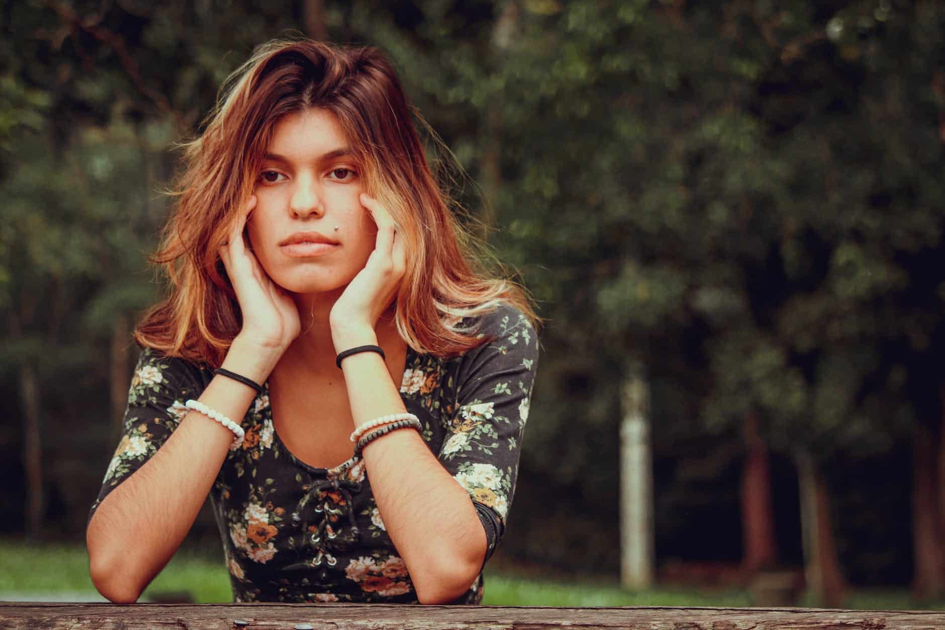 thoughtful young woman resting in green park