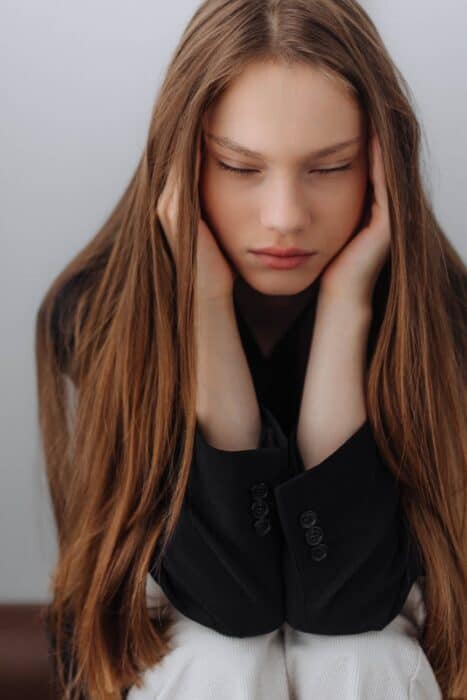 portrait of woman covering ears with hands