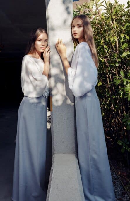 twins leaning on a pillar